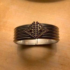 Heavy metal hinged bracelet in silver/ gold tones.